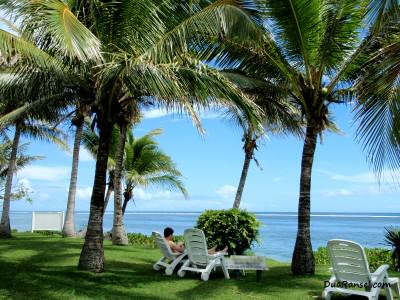 Bersantai di bawah pohon kelapa dengan laguna terhampar di depan mata